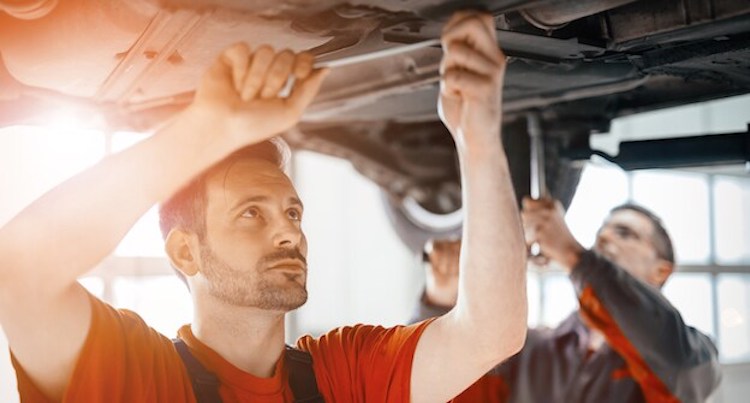 mechanics working under the car hood