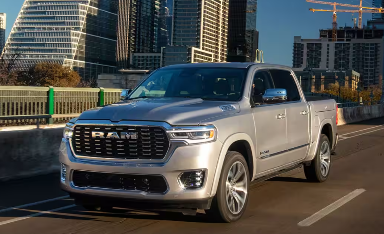 A 2025 RAM 1500 driving on a city road with a tall construction crane in the background